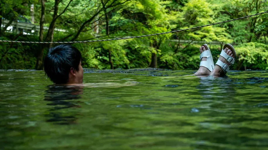 埼玉県飯能市のサウナンヤルケンで、名栗の清流に入り天然水風呂を楽しむ様子